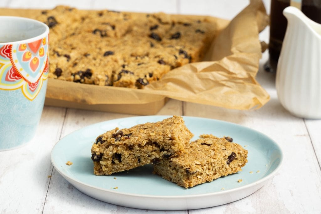 Sultana and Raisin Flapjacks on a plate with coffee cup and milk