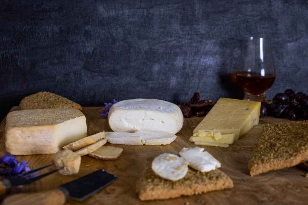 Cheeses on a cheeseboard with oat cakes and wine